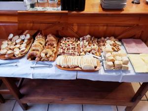 una mesa llena de diferentes tipos de sándwiches y repostería en Hosteria Maiten Escondido en Villa La Angostura