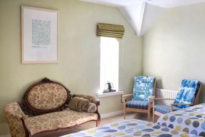 1 dormitorio con 2 sillas, 1 cama y 1 ventana en Old Schoolhouse B and B, en Enniskillen