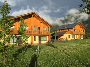 two large wooden houses in a field of grass at Les Chalets Fleurs de France - KOTA in Saint-Dalmas