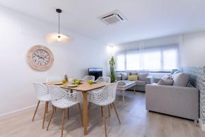 een woonkamer met een tafel en stoelen en een bank bij Livemalaga Balneario Beach in Málaga