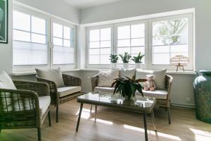 a living room with chairs and a table and windows at Viigi Villa in Haapsalu