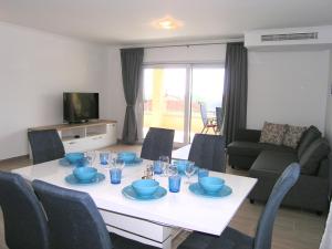 a living room with a white table with blue dishes on it at Apartmani Krajinovic in Krk