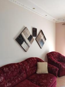 a living room with a red couch and three pictures on the wall at Elpida Apartment in Limenas