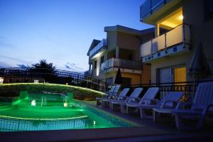 una piscina con sedie e un campo da mini golf di Funtana Appartements an der 1 Reihe vom Meer a Funtana