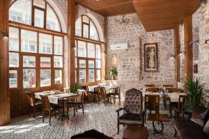 a restaurant with tables and chairs in a room with windows at LUWİ ANTAKYA BOUTİQUE HOTEL in Hatay