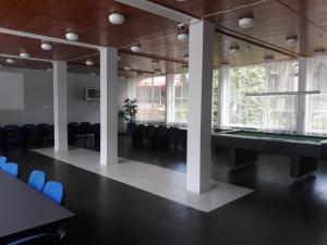 a large room with chairs and a table and windows at Prima in Krynica Morska