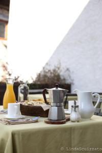 una mesa con un hervidor de agua y un plato de comida en Il Capriolo Felice - Agriturismo en Lastebasse