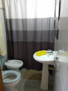 a bathroom with a sink and a toilet and a shower at Completa casa en Colonia para 6 personas in Colonia del Sacramento
