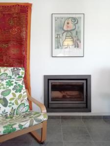 a living room with a fireplace and a chair at Casa Luminosa in Carrapateira