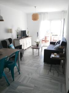 salon z kanapą i stołem w obiekcie Precioso apartamento en primera línea de playa de la Barrosa w mieście Chiclana de la Frontera