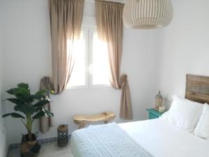 sypialnia z łóżkiem i oknem w obiekcie Precioso apartamento en primera línea de playa de la Barrosa w mieście Chiclana de la Frontera