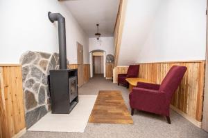 a living room with a wood stove and chairs at Penzion Svatý Petr in Boží Dar