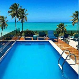 a swimming pool with a view of the beach at Hotel do Mar Cabo Branco in João Pessoa