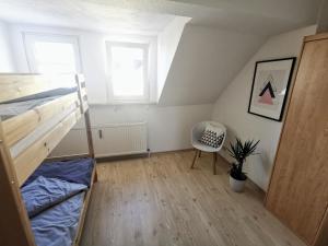 1 dormitorio con litera y silla en Moderne 3BR Netflix,Kaffee,Wifi,Parken, en Brand-Erbisdorf