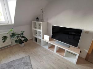 ein Wohnzimmer mit einem Flachbild-TV auf einem weißen Stand in der Unterkunft Moderne 3BR Netflix,Kaffee,Wifi,Parken in Brand-Erbisdorf