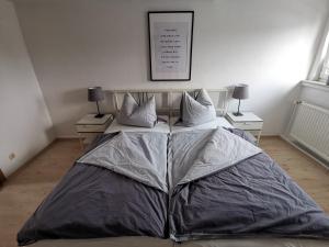 a large bed in a bedroom with two night stands at Moderne 3BR Netflix,Kaffee,Wifi,Parken in Brand-Erbisdorf