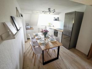 y cocina con mesa, sillas y nevera. en Moderne 3BR Netflix,Kaffee,Wifi,Parken, en Brand-Erbisdorf