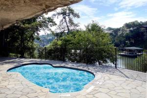 a small swimming pool in a patio with a fence at Lakefront Treehouse on Lake Travis Pool & Hot Tub in Lakeway