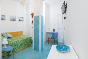 een kleine kamer met een bed, een tafel en een stoel bij La Casetta Linda - New 2 Bedroom Apt in Sorrento with seaview Terrace in Sorrento