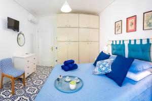een slaapkamer met een blauw bed en een dienblad bij La Casetta Linda - New 2 Bedroom Apt in Sorrento with seaview Terrace in Sorrento