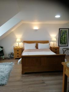 a bedroom with a bed with two night stands and two lamps at Woodend in Glenrothes