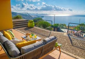 ein Wohnzimmer mit einem Sofa und Meerblick in der Unterkunft Villa Sunrise View by Madeira Sun Travel in Santa Cruz