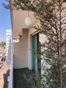 a building with a window next to a tree at Hotel Carajás in Varginha