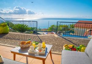 einen Tisch mit einer Obstschale auf dem Balkon in der Unterkunft Villa Sunrise View by Madeira Sun Travel in Santa Cruz