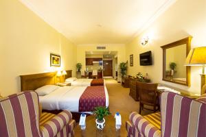 Rolla Residence Hotel Apartment في دبي: فندق غرفه بسرير وصاله