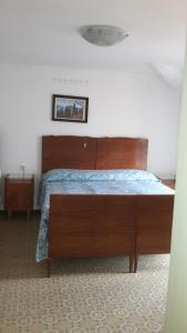 a bedroom with a large bed with a wooden headboard at Appartamenti Azzone in Azzone