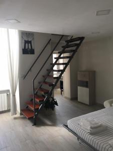 eine schwarze Treppe in einem weißen Zimmer mit einem Bett in der Unterkunft CASA GIULIETTA in Vico Equense