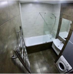 een badkamer met een bad, een wastafel en een spiegel bij LOFT - Interior design apartments in Oral