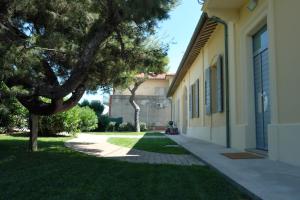 a building with a tree next to a sidewalk at INVENTO bnb unconventional maison in Civitanova Marche