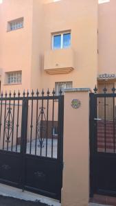 a black gate in front of a building at Cozy rooms in terraced house in Fuengirola