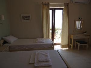 a hotel room with two beds and a window at Maria & Kiki 1 Studios in Mithymna