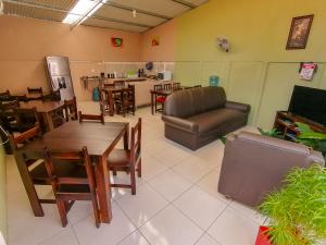 a living room with a couch and tables and chairs at Nice Place Hostel in Fortuna
