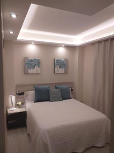 ein Schlafzimmer mit einem großen weißen Bett mit blauen Kissen in der Unterkunft Apartamentos Vacacionales Joctis, 2º B in Fuengirola