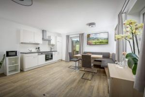 a living room with a kitchen and a dining room at Kaiserwinkl Apartments Daxer in Walchsee