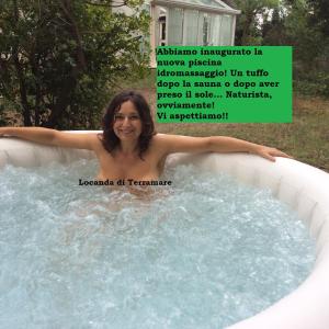 uma mulher numa banheira de hidromassagem num quintal em Locanda di Terramare em Gabbro