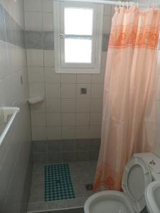 a bathroom with a shower with a toilet and a window at Nikolettas Apartments in Faros +19 photos
