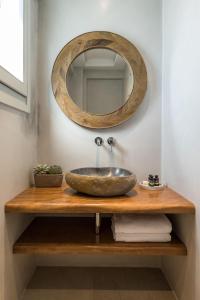 a bathroom with a sink and a mirror at Virtu Suites in Agios Prokopios