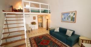 a living room with a couch and a spiral staircase at Hotel Masseria Tutosa in Ostuni