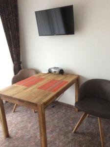 a wooden table with two chairs and a television on a wall at Appartement Bergblick in Raggal