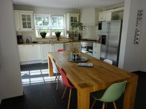 澤沃德的住宿－Holiday Home Zeewolde，厨房配有木桌、椅子和冰箱