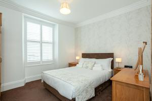 凯西克Carlton 2 a large modern Keswick appt with parking的一间卧室，配有一张床、一张书桌和一扇窗户
