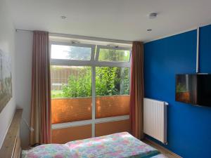 Un dormitorio con una gran ventana y una cama en frente. en Ferienhaus Maxe, en Fehmarn