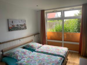 Zimmer mit 2 Betten vor einem Fenster in der Unterkunft Ferienhaus Maxe in Fehmarn