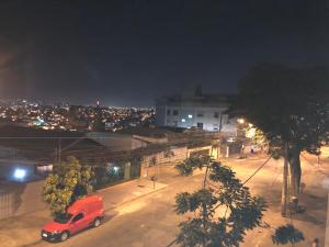 un camion rosso parcheggiato su una strada cittadina di notte di Apartamento Caiçaras a Belo Horizonte