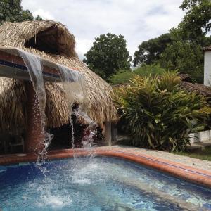 una piscina con cascada en un complejo en Villa de las Palmas de Rozo Palmira, en Rozo