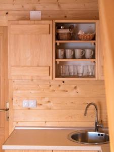 een keuken met houten kasten en een wastafel bij Holiday Homes Eko Klanac in Rakovica